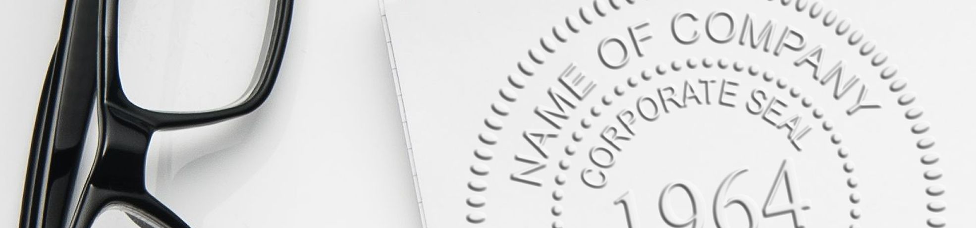 Black eyeglasses beside a document embossed by Corporate Seal Embossers reading “Name of Company” and “Corporate Seal 1964.”