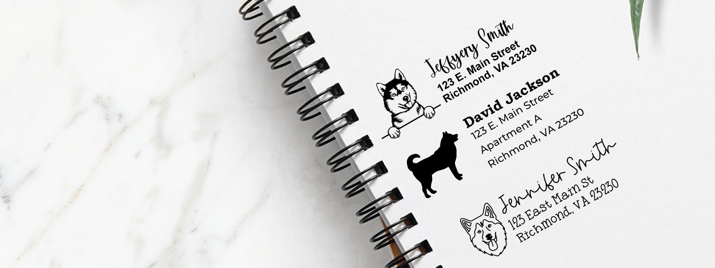 Open spiral notebook on white marble with three dog address labels; Husky Dog Stamps and Custom Seals for Jeffrey, David, and Jennifer Smith, Richmond VA.