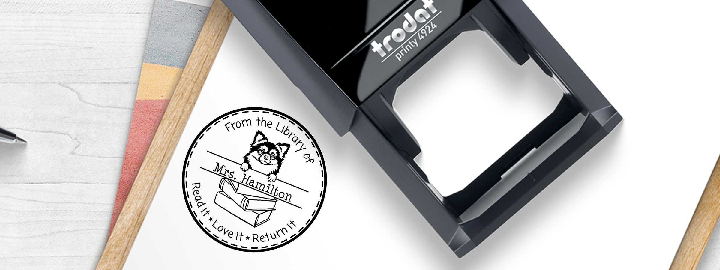 Black Trodat Printy 4924 beside a library book stamp and Long Haired Chihuahua Dog Stamps and Custom Seals design with dog peeking over books.