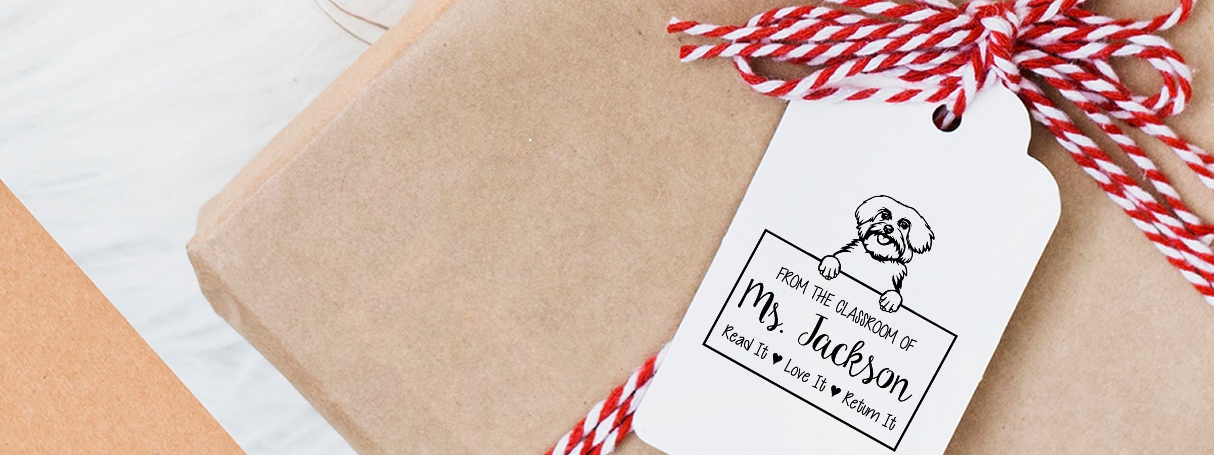 Wrapped gift with white hang tag, dog illustration, and “Read it, Love it, Return it” using Maltese Dog Stamps and Custom Seals.