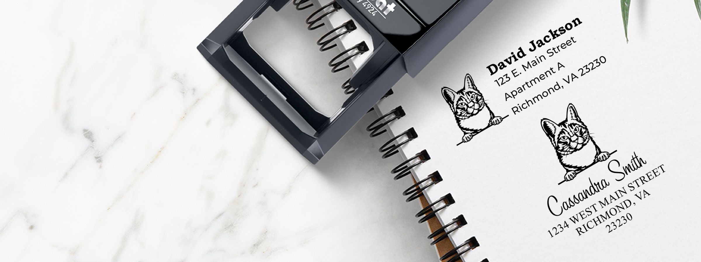 Notebook mockup with two black self-inking stampers and cat return-address labels for David Jackson and Cassandra Smith, Manx Cat Stamps and Custom Seals.