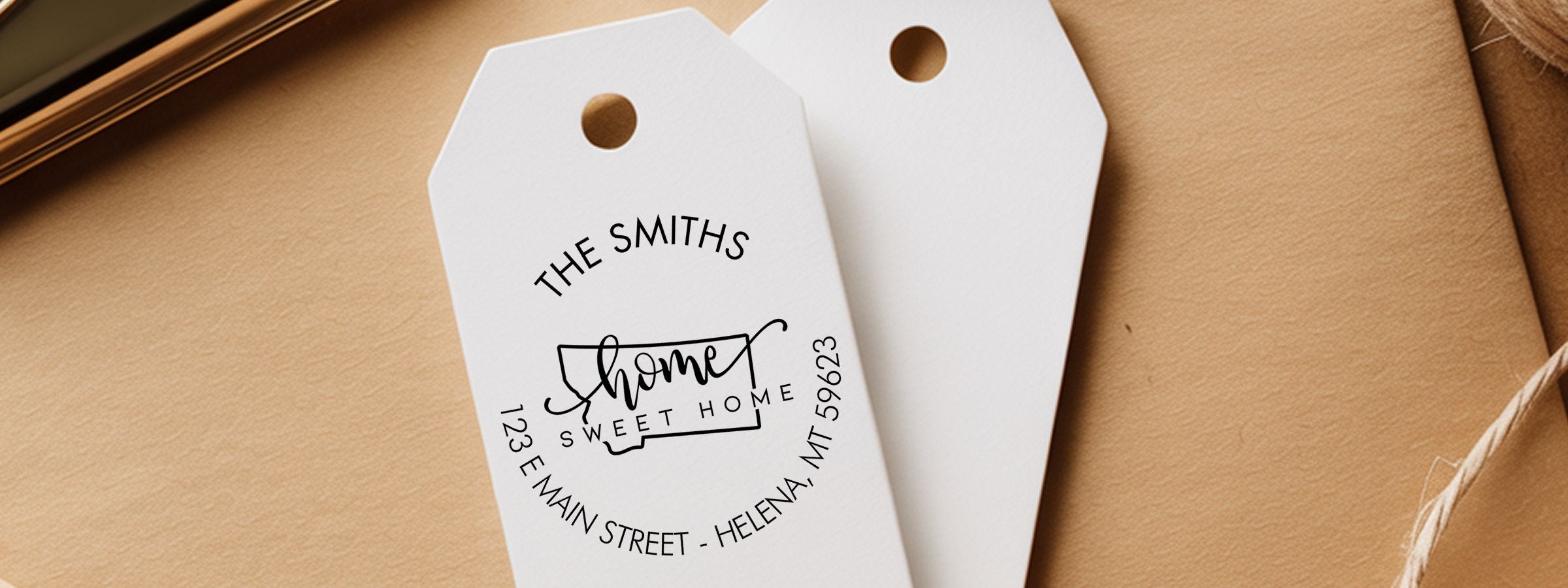 Two white gift tags on brown paper, one reading “The Smiths” and “home sweet home” with Helena, MT address; Montana Designer Stamps and Seals.