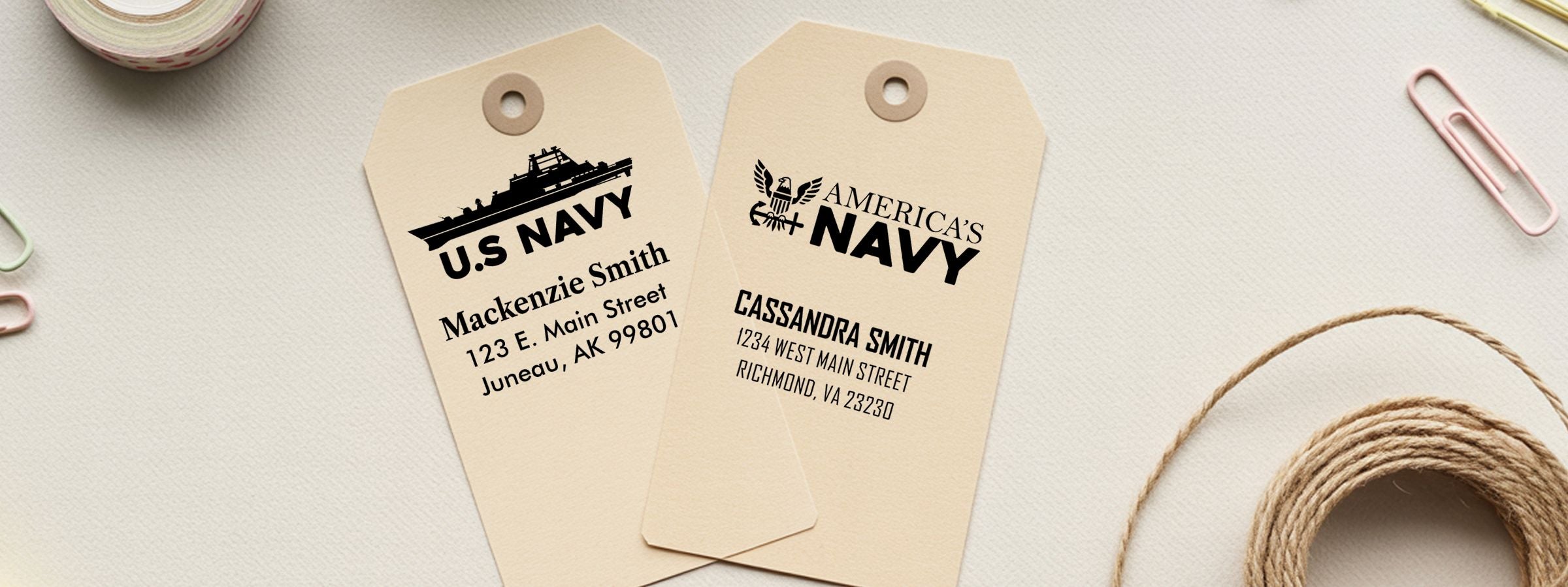 Two beige U.S. Navy gift tags with sample names and addresses, beside paper clips and twine; Navy Designer Stamps.