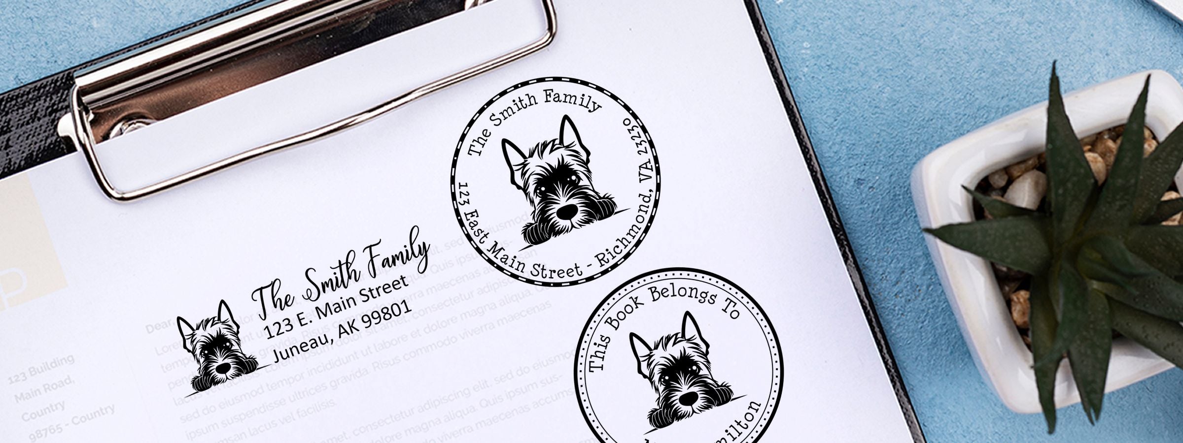 Clipboard with Scottish Terrier Dog Stamps and Custom Seals, family address labels, and a “This Book Belongs To” stamp beside a succulent.