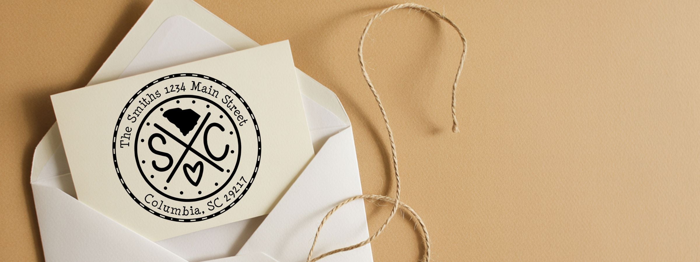 Open white envelope with cream monogram card on beige twine, featuring The Smiths address logo for South Carolina Designer Stamps and Seals.