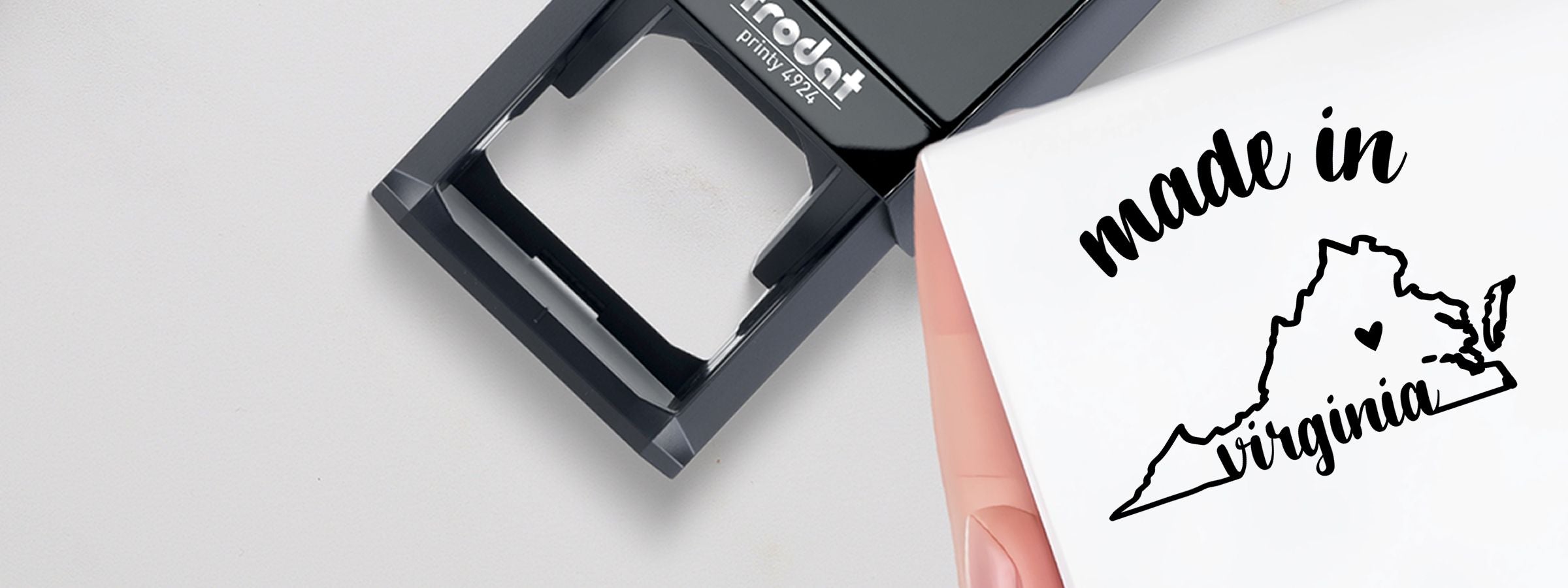 White shirt printed with “made in Virginia” in black script over Virginia outline and heart, with a black self-inking stamp from Virginia Designer Stamps and Seals.