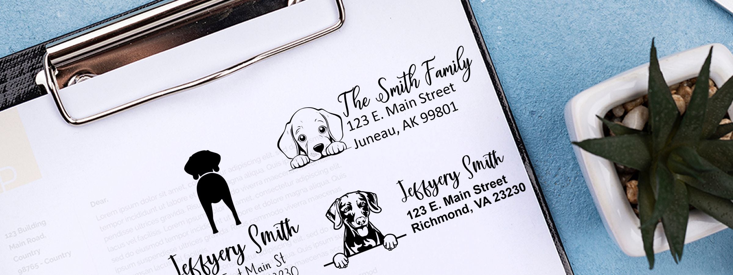 Clipboard with dog address label designs, sample names, succulent, and Weimaraner Dog Stamps and Custom Seals on blue.