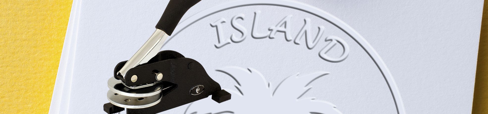 Custom Artwork Embossers in action, embossing an ISLAND logo with palm tree design on white paper.