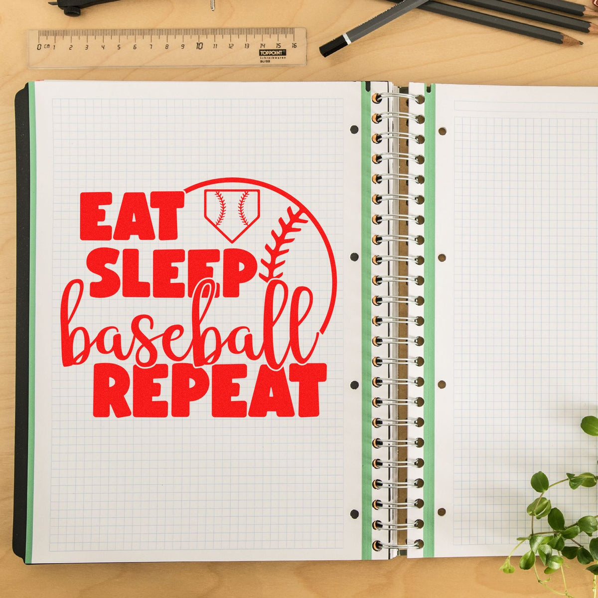 Baseball-themed rubber stamp design with Eat Sleep Baseball Repeat in red on a notebook page.