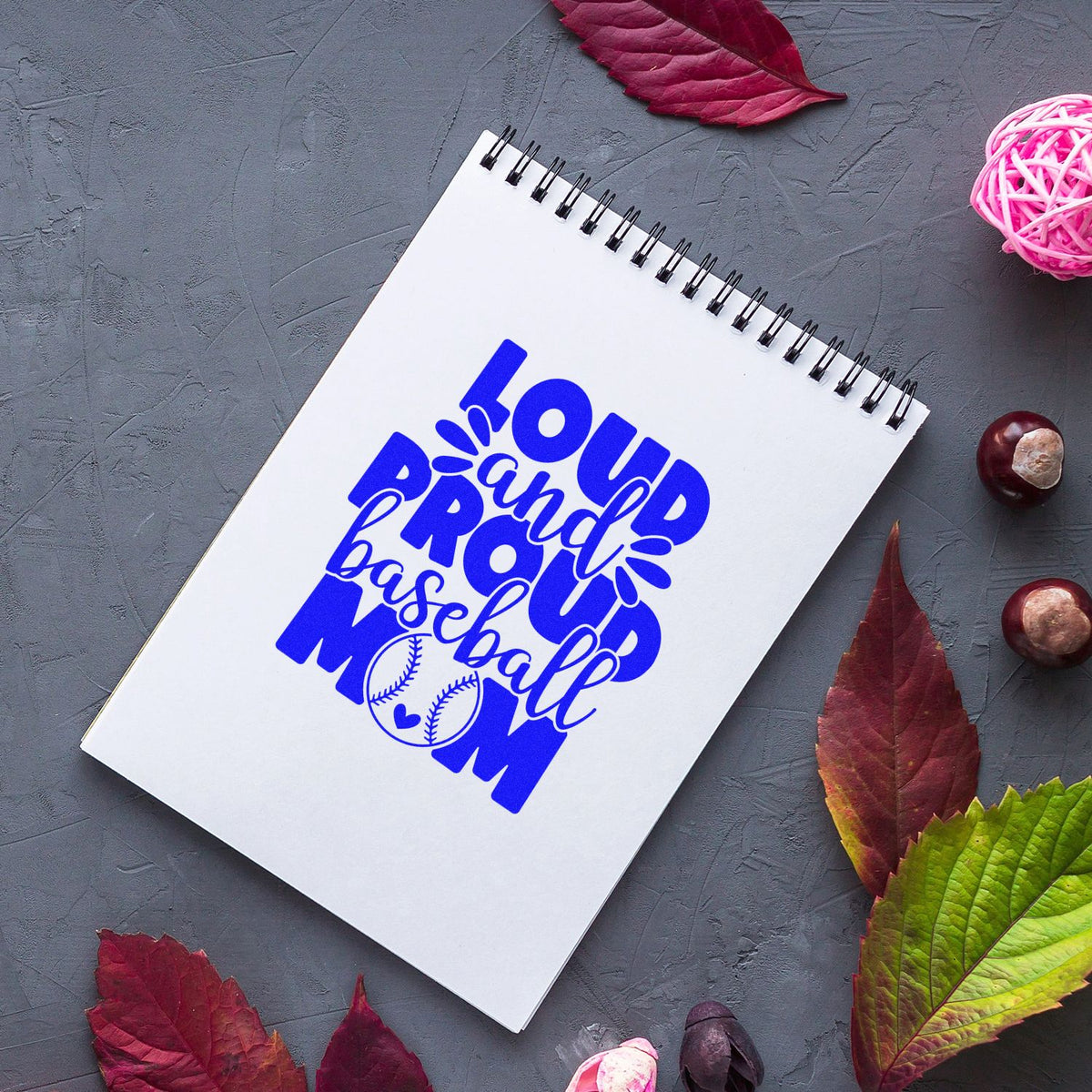 Baseball mom rubber stamp design on notebook with bold blue lettering for custom sports crafts and stationery.