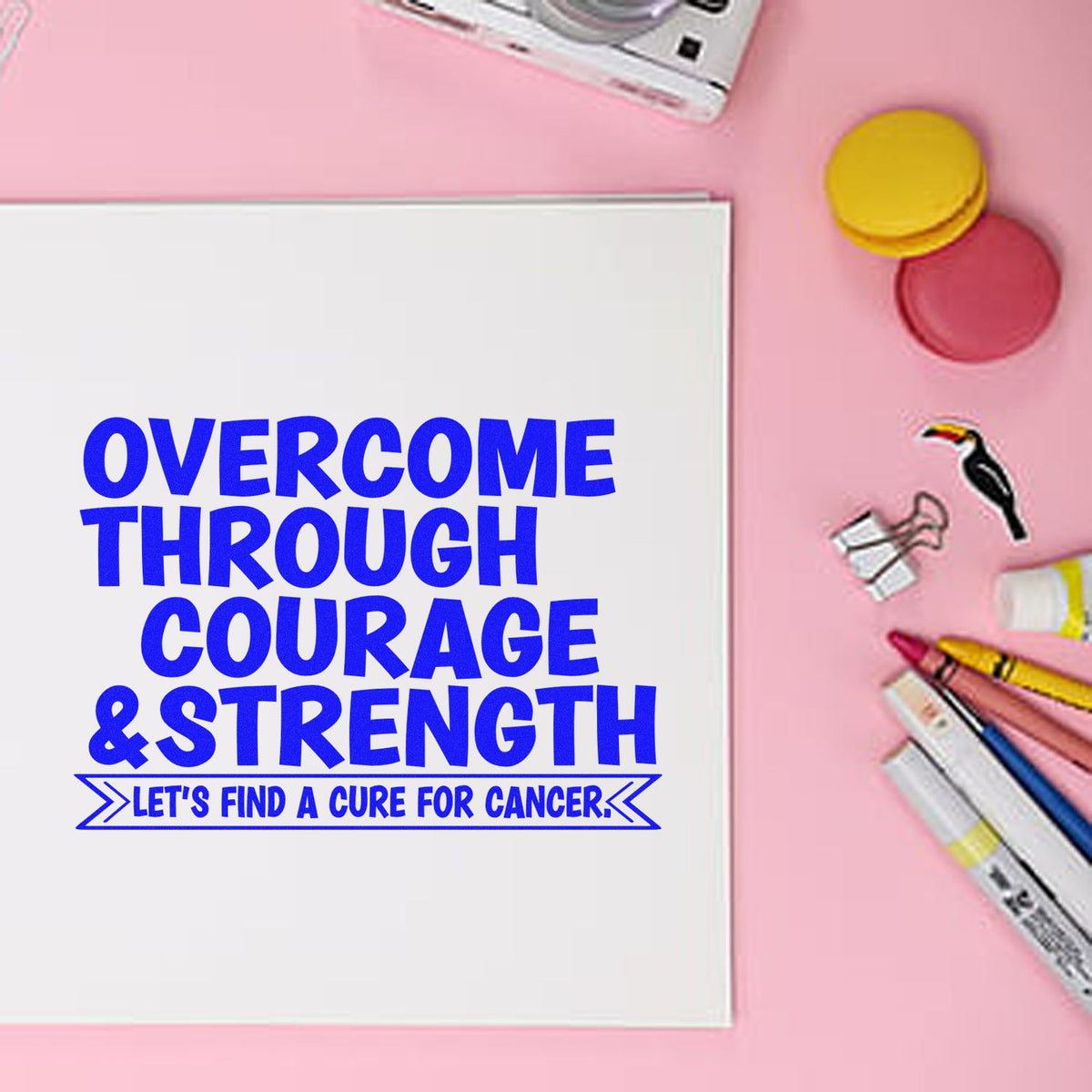 Cancer awareness rubber stamp design with Overcome Through Courage & Strength and Lets find a cure for cancer on paper.