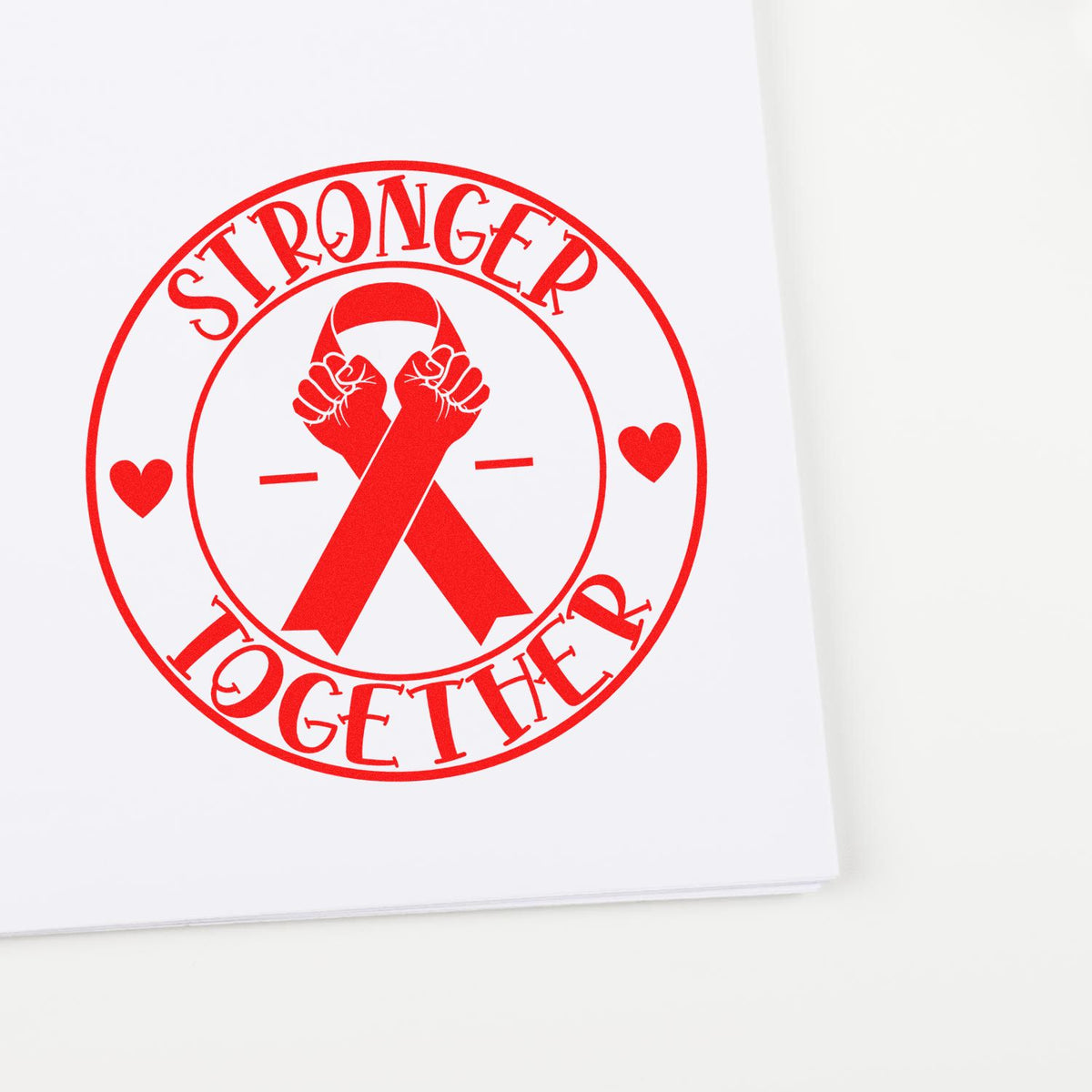 Red Stronger Together rubber stamp design with cancer ribbon and hearts, symbolizing support and unity on paper.