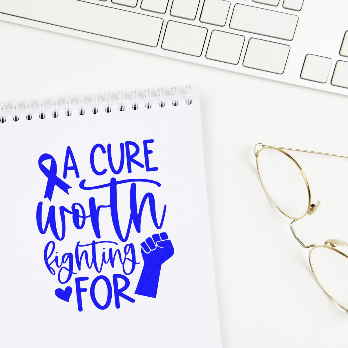 Breast cancer awareness rubber stamp design reading A Cure Worth Fighting For with ribbon and fist on notebook.