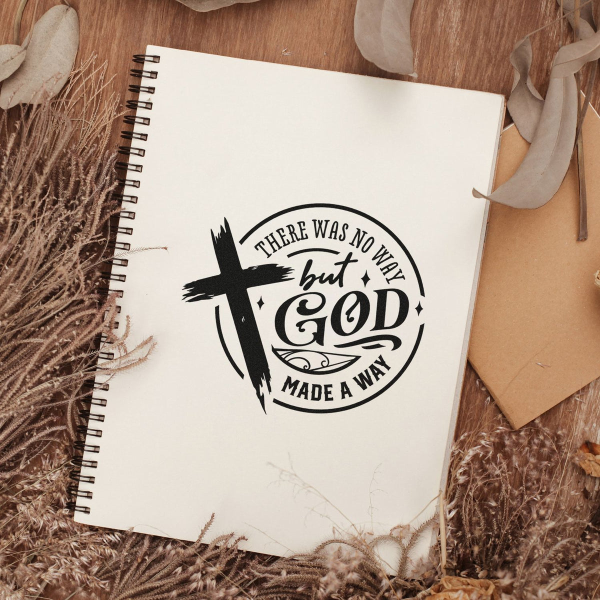 Christian rubber stamp design on notebook reading There Was No Way But God Made a Way with cross and rustic decor.