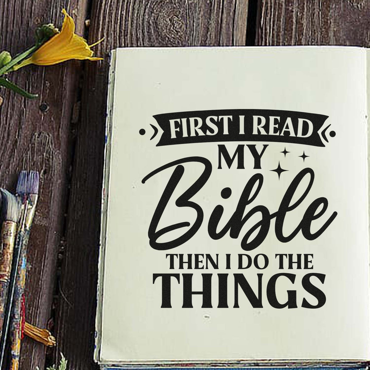 Bible journaling rubber stamp with quote, First I read my Bible then I do the things, on an open notebook.