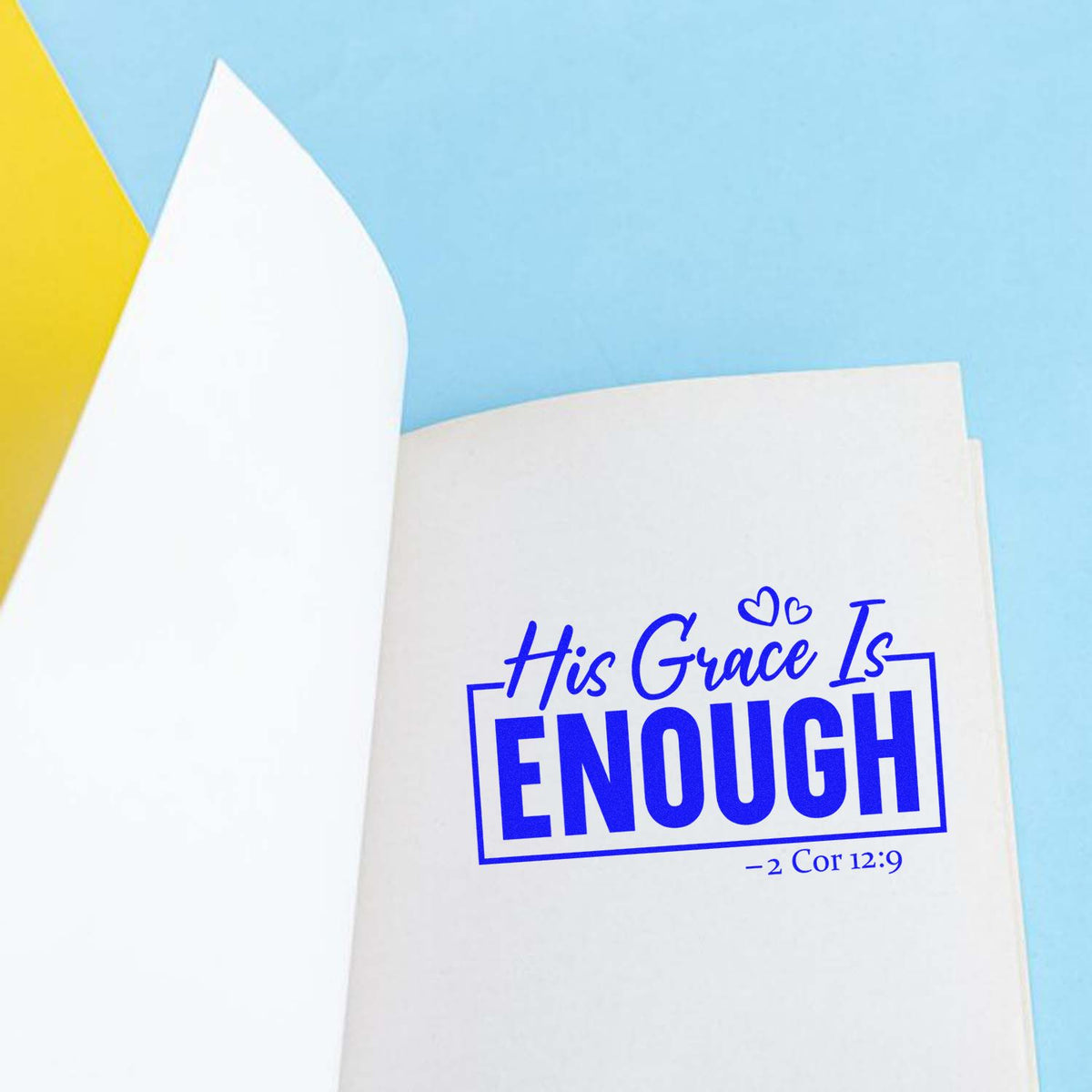 Christian rubber stamp design with His Grace Is Enough Bible verse from 2 Corinthians 12:9 on notebook paper.