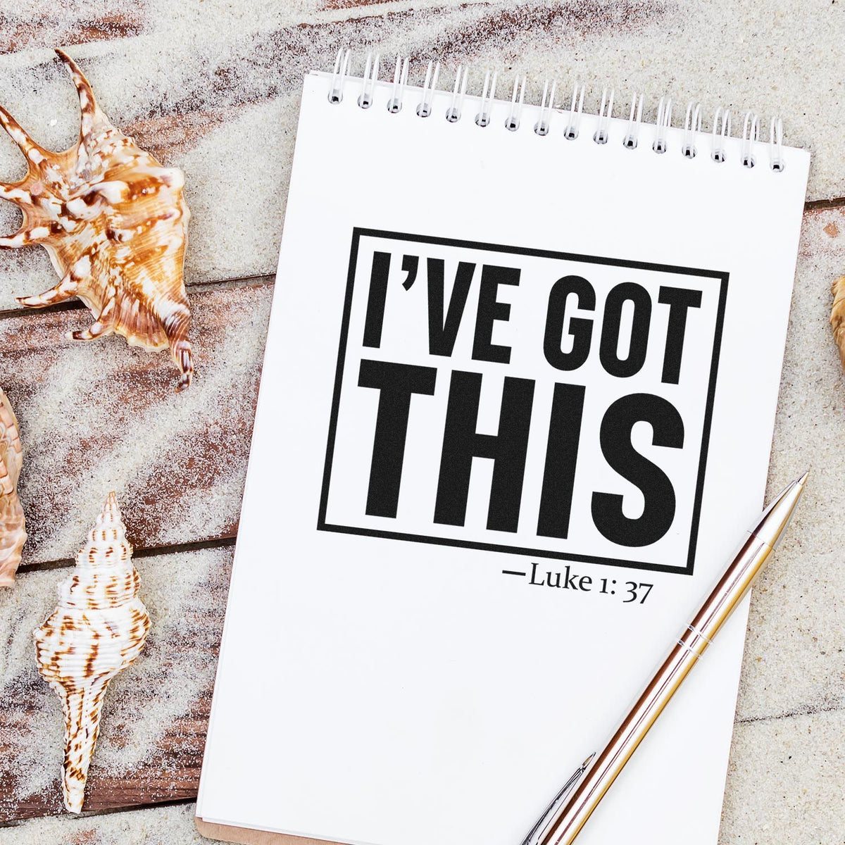 Christian rubber stamp design reading Ive Got This Luke 1:37 on a notepad, styled with seashells and pen.