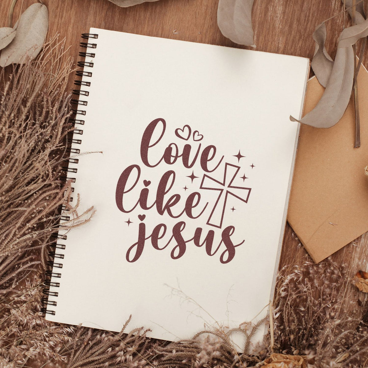 Love Like Jesus rubber stamp design on spiral notebook, featuring a cross and hearts for Christian journaling and Bible crafts.