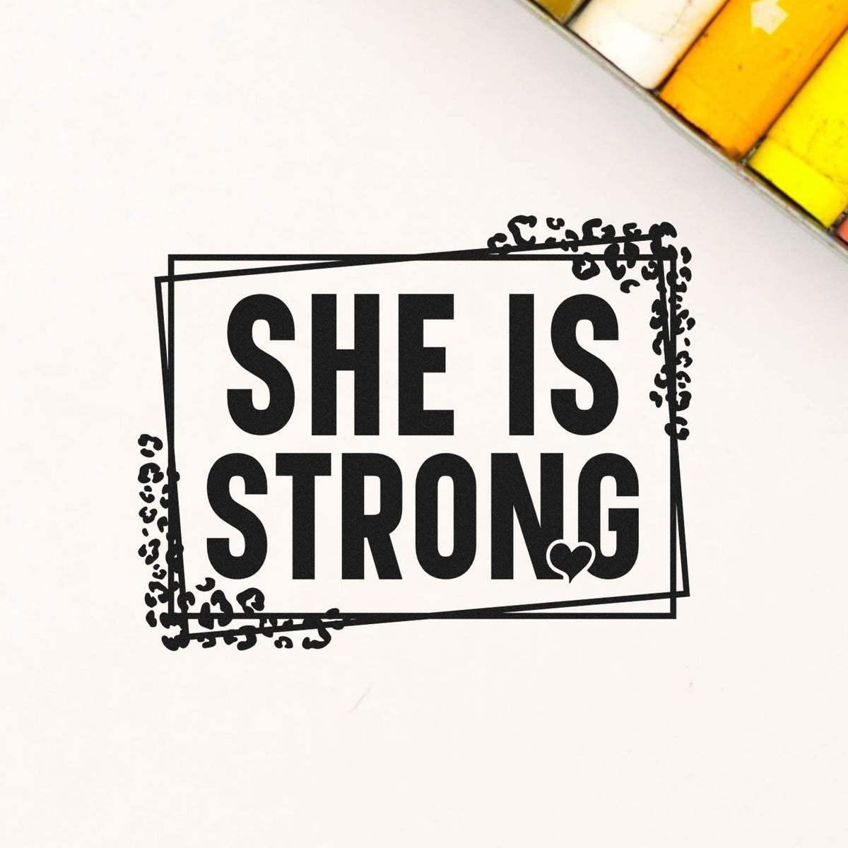 She Is Strong rubber stamp design with bold text and decorative frame for inspirational craft projects.