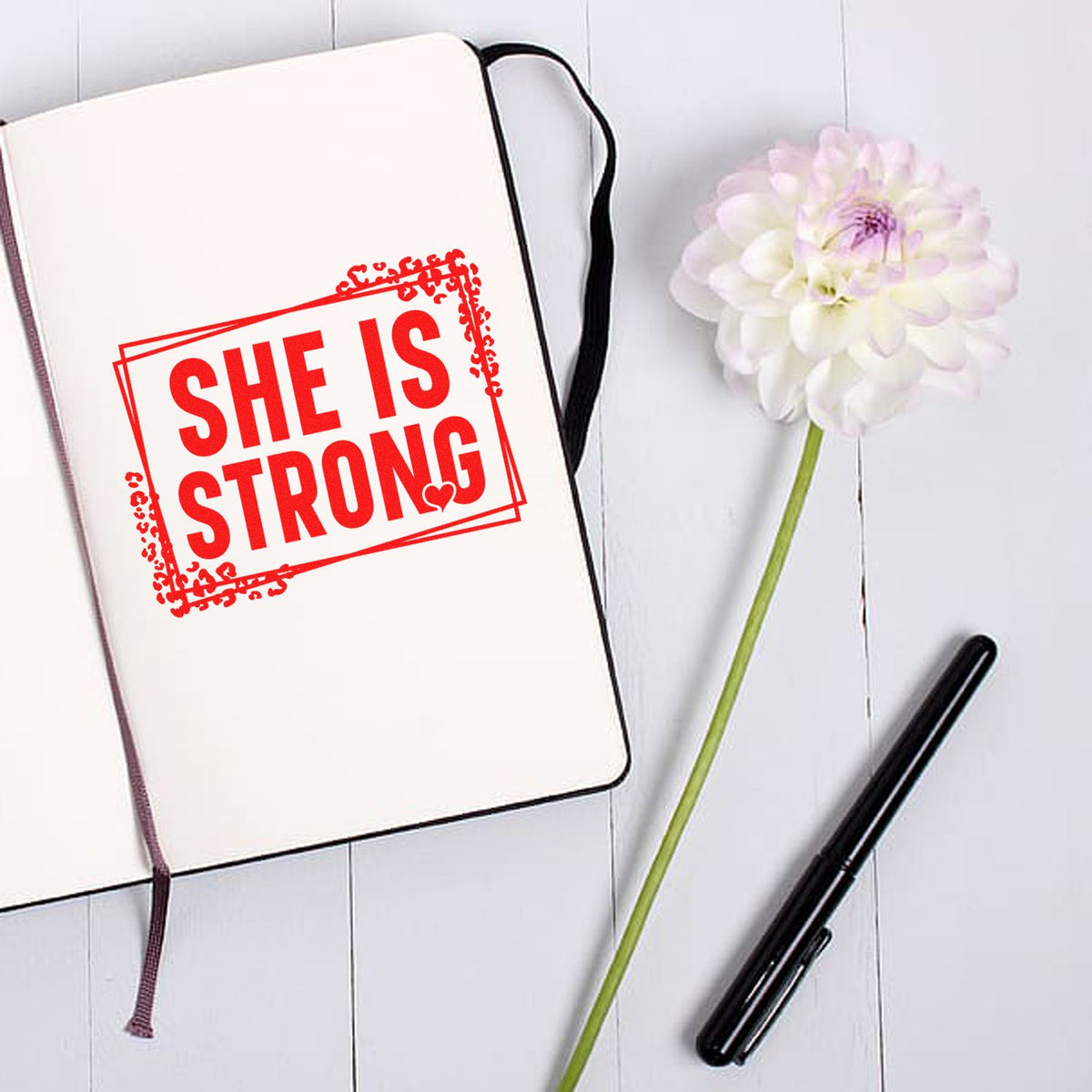 She Is Strong rubber stamp on journal page, ideal for inspirational planner, scrapbooking, and female empowerment crafts.