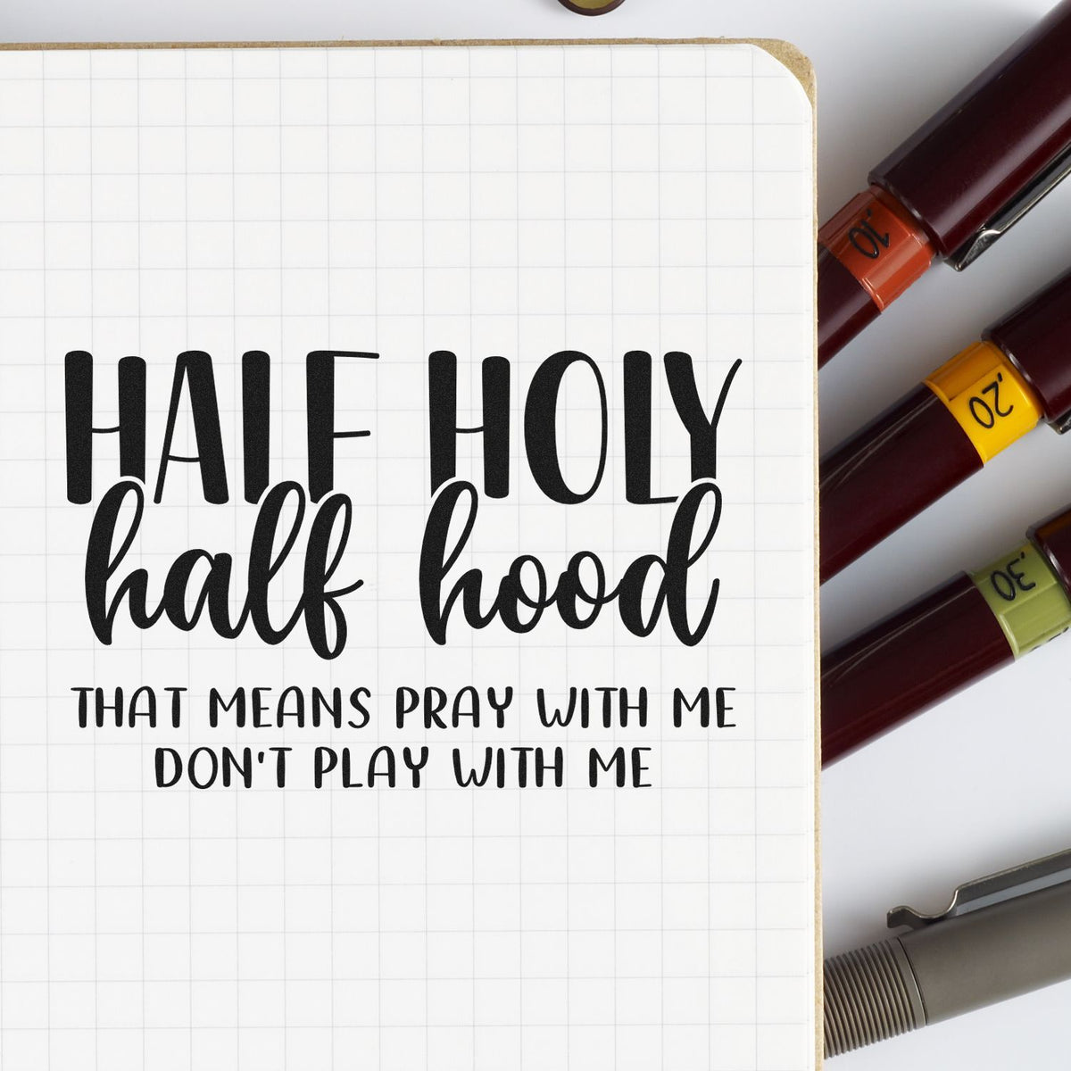 Half Holy Half Hood rubber stamp design with Christian quote, Pray with me, dont play with me, on grid notebook page.