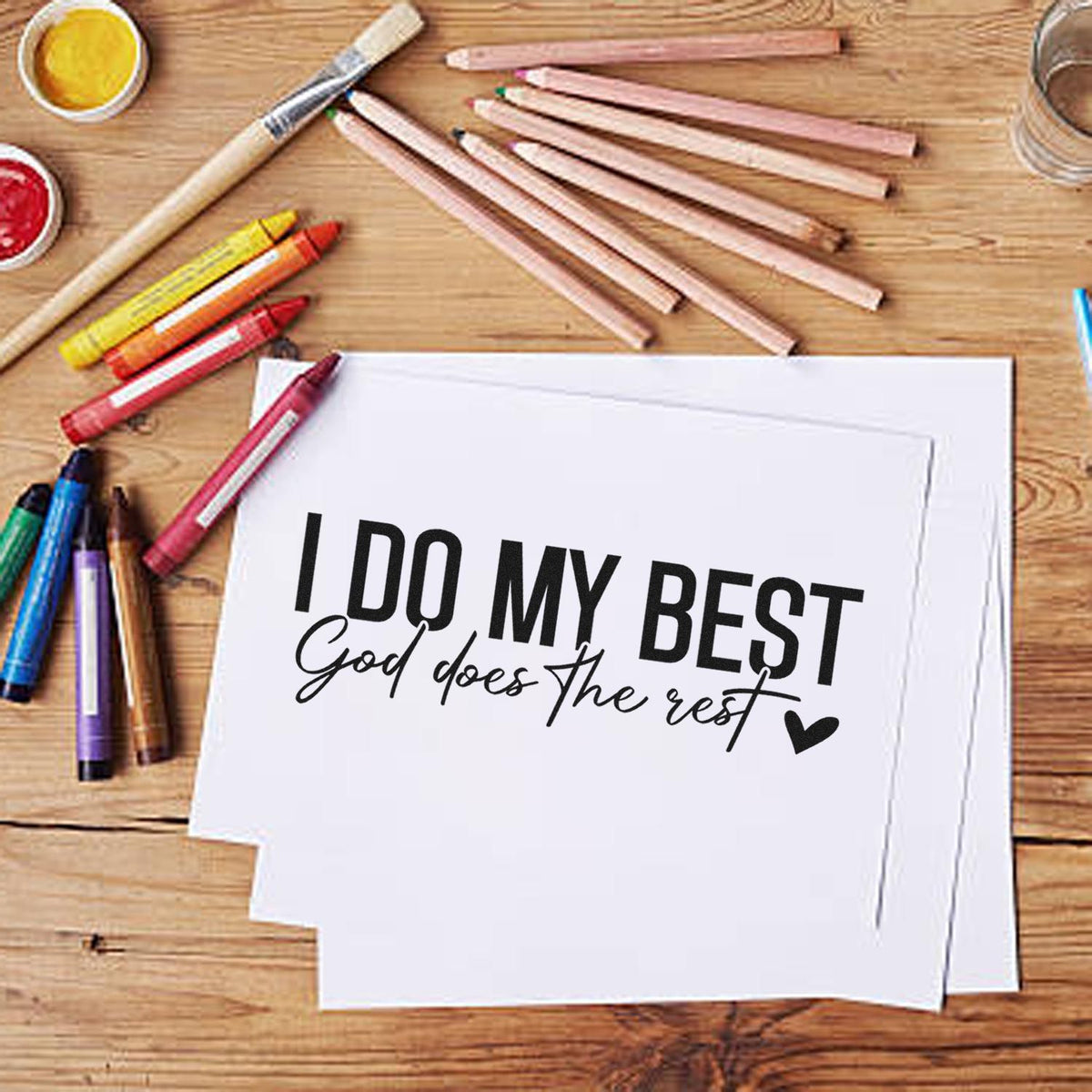Christian rubber stamp design reading I Do My Best, God Does the Rest with art supplies on a wooden craft table.