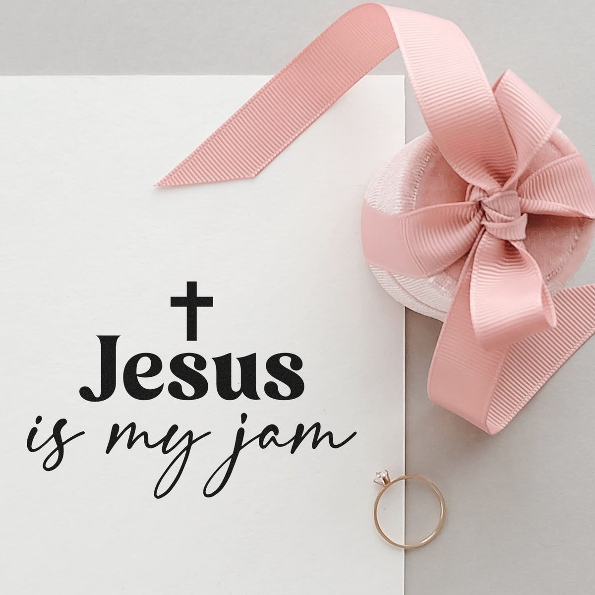 Religious rubber stamp design reading Jesus is my jam on a white envelope with pink ribbon bow.