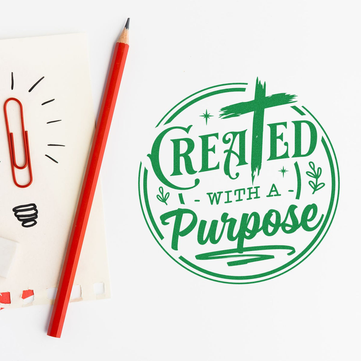 Custom rubber stamp design reading Created with a Purpose in green, shown with pencil and sketch pad mockup.