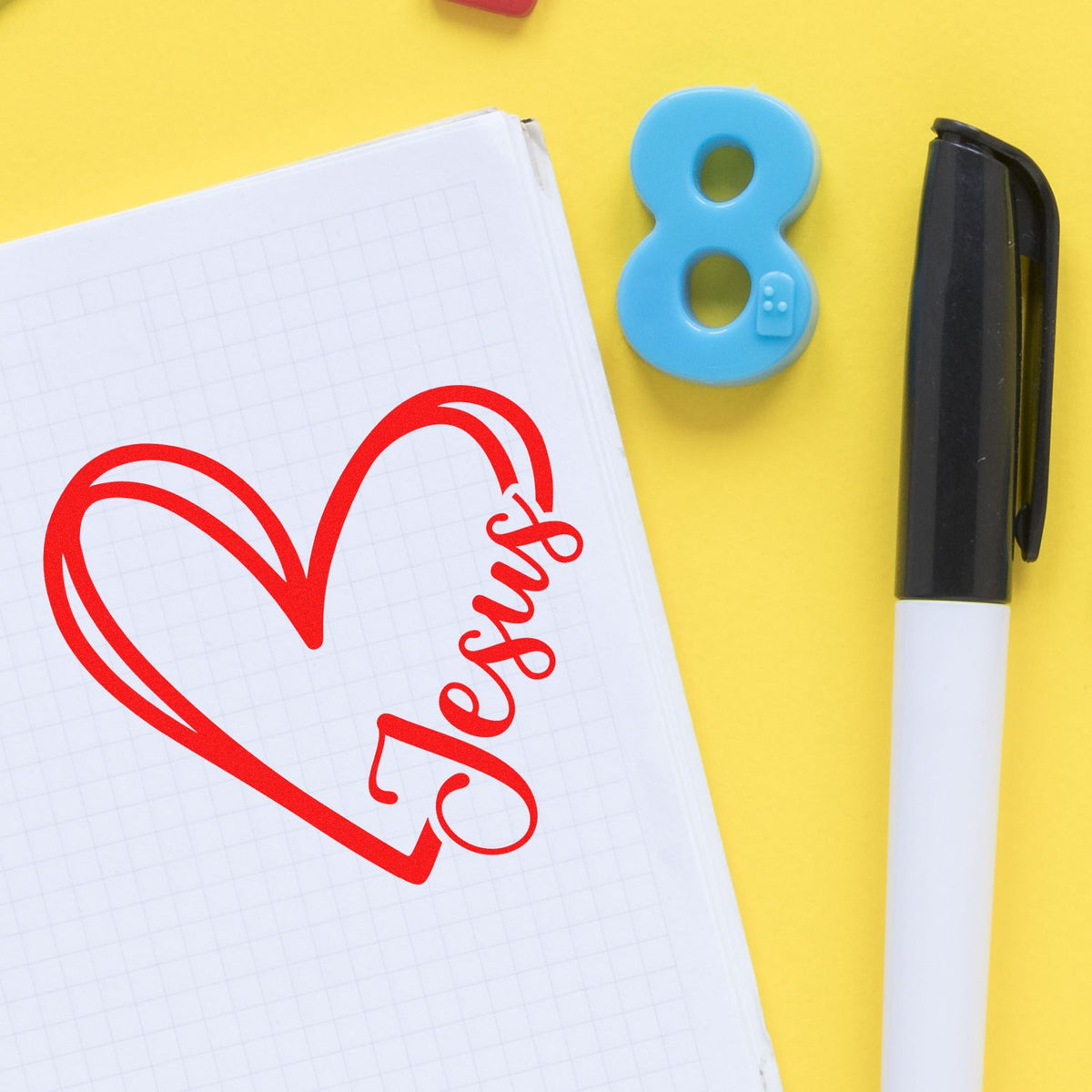 Custom rubber stamp design with heart and name Jens on notebook, ideal for personalized school supplies.