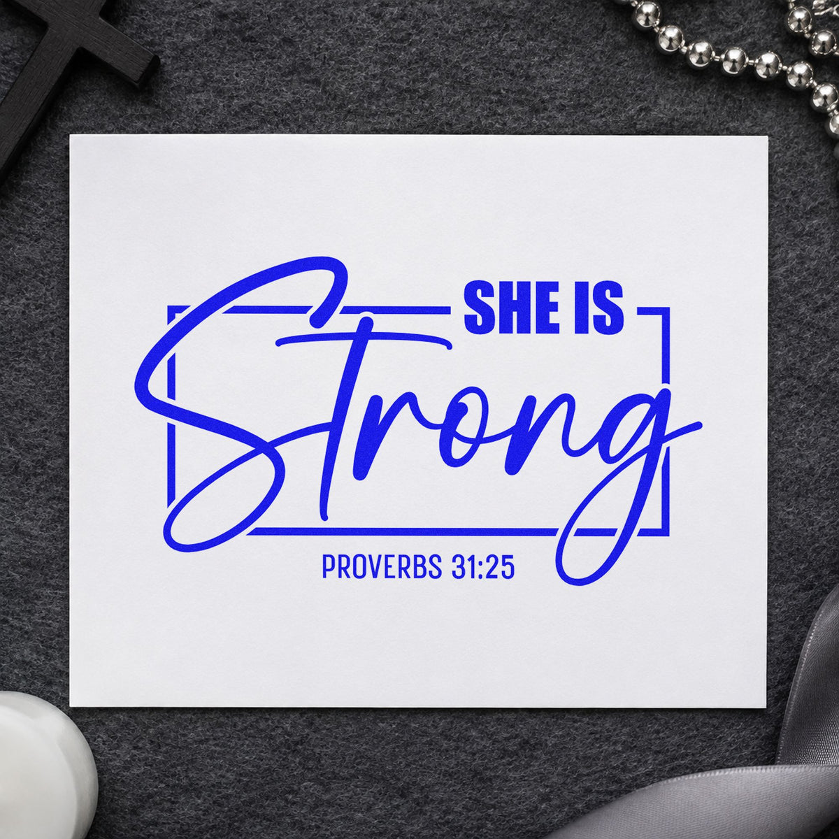 She Is Strong Script craft stamp imprinted in blue ink on paper, a design suited to survivor gift tags.