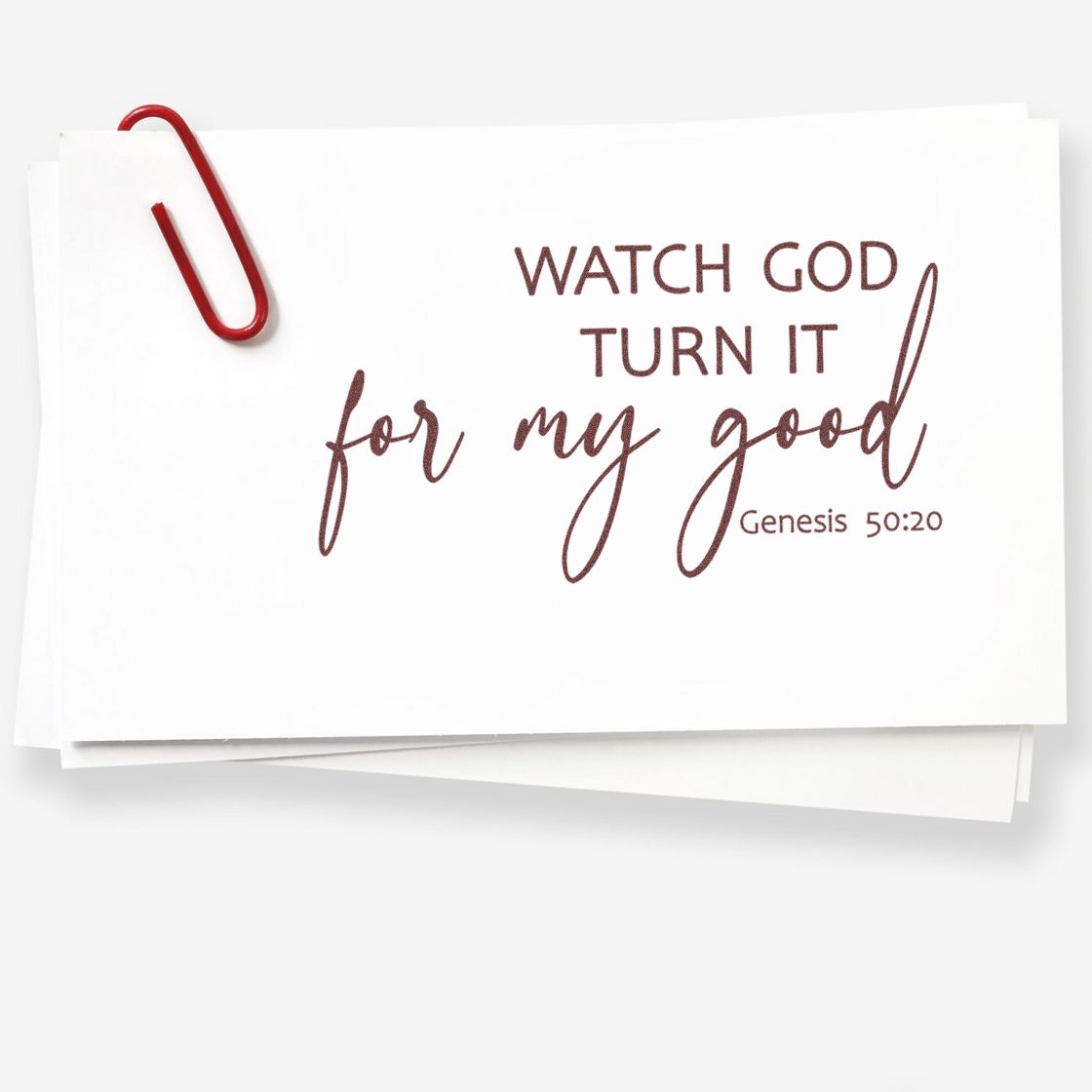 Christian rubber stamp with Bible verse Watch God turn it for my good from Genesis 50:20 on white paper.