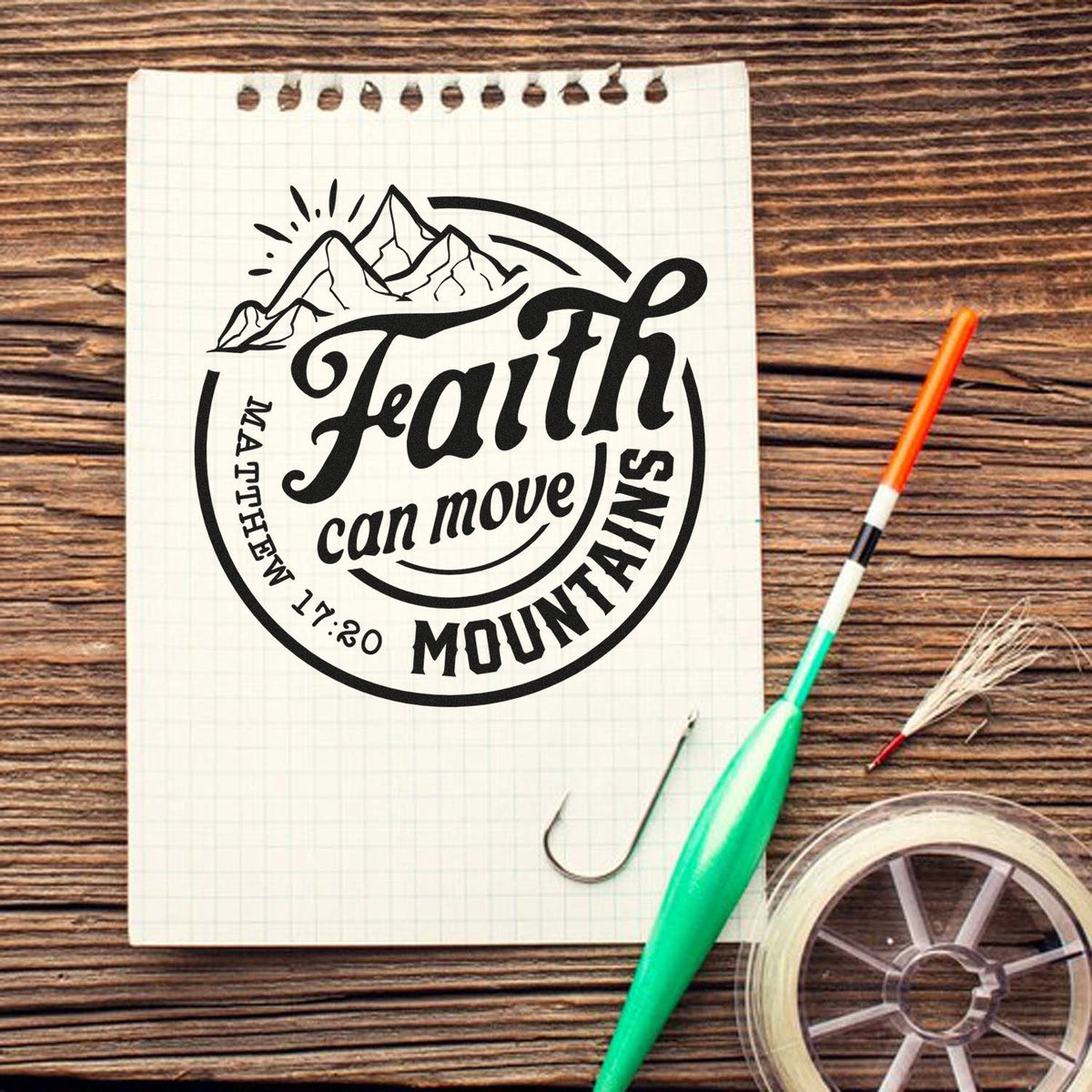 Custom rubber stamp design with mountain graphic and Faith can move mountains Matthew 17:20 on notebook paper.