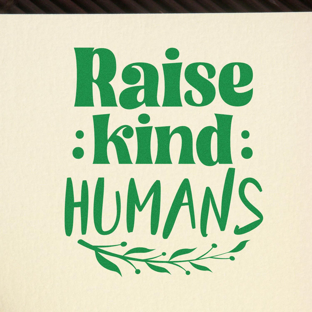 Green Raise Kind Humans custom rubber stamp design with decorative leaf flourish for teacher, nursery, or parenting gifts