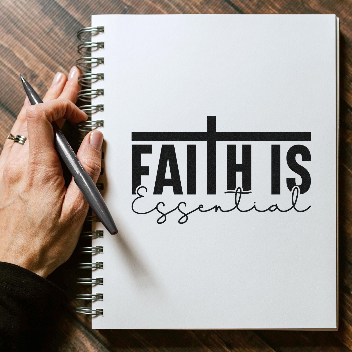 Faith Is Essential rubber stamp on notebook page, ideal for faith-based journaling, planners, and craft projects.