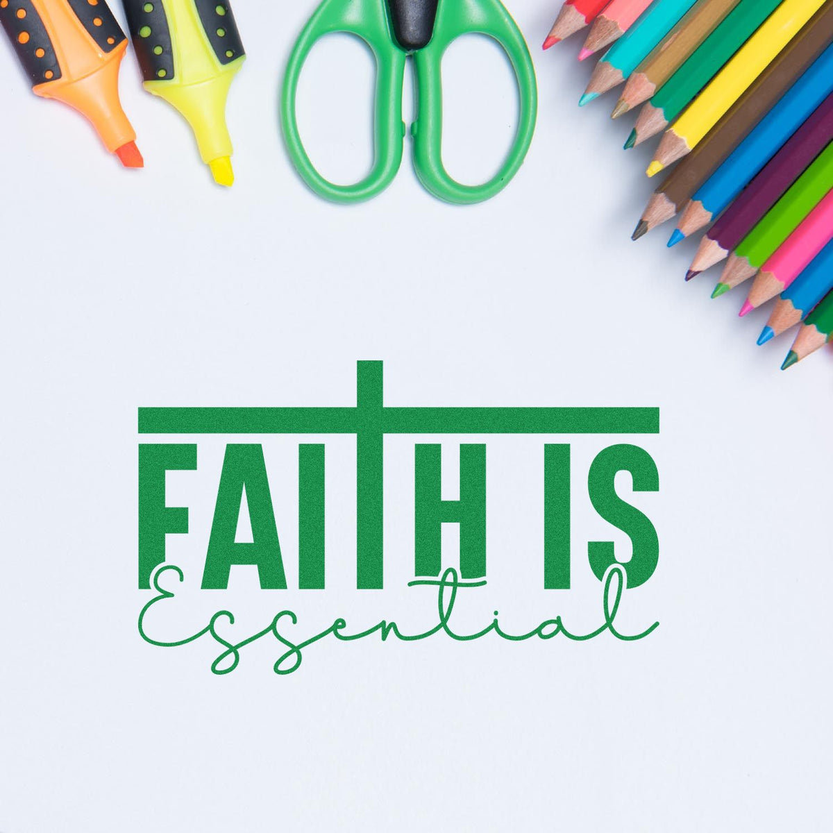 Faith Is Essential rubber stamp design in green, framed by colorful pencils, scissors, and markers on a white background.