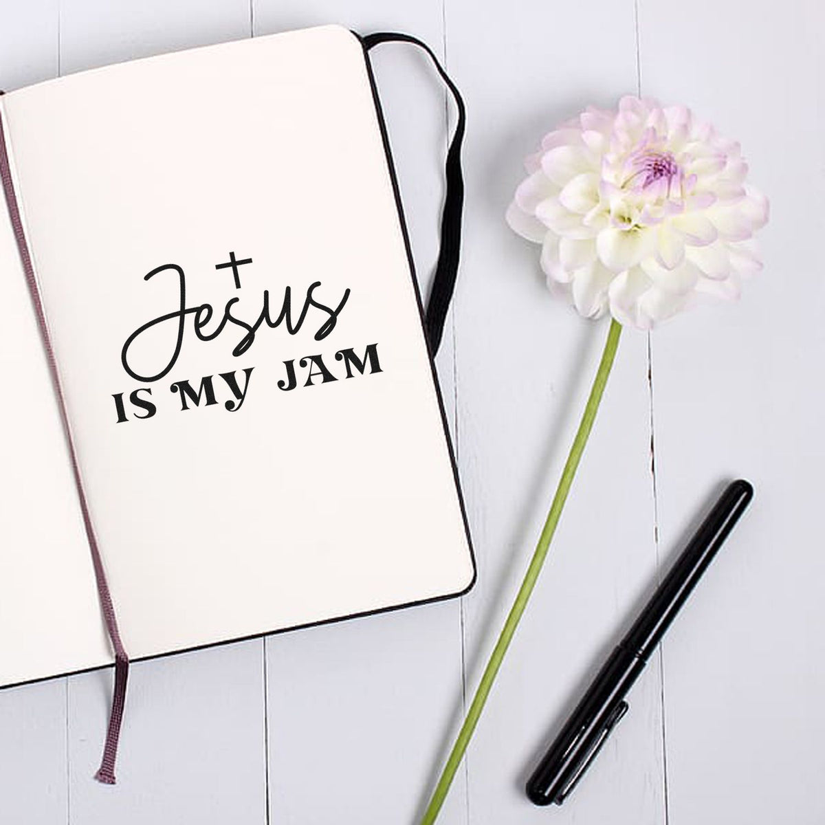Jesus is my jam rubber stamp design on notebook with flower and pen, perfect for Christian planners and journaling.