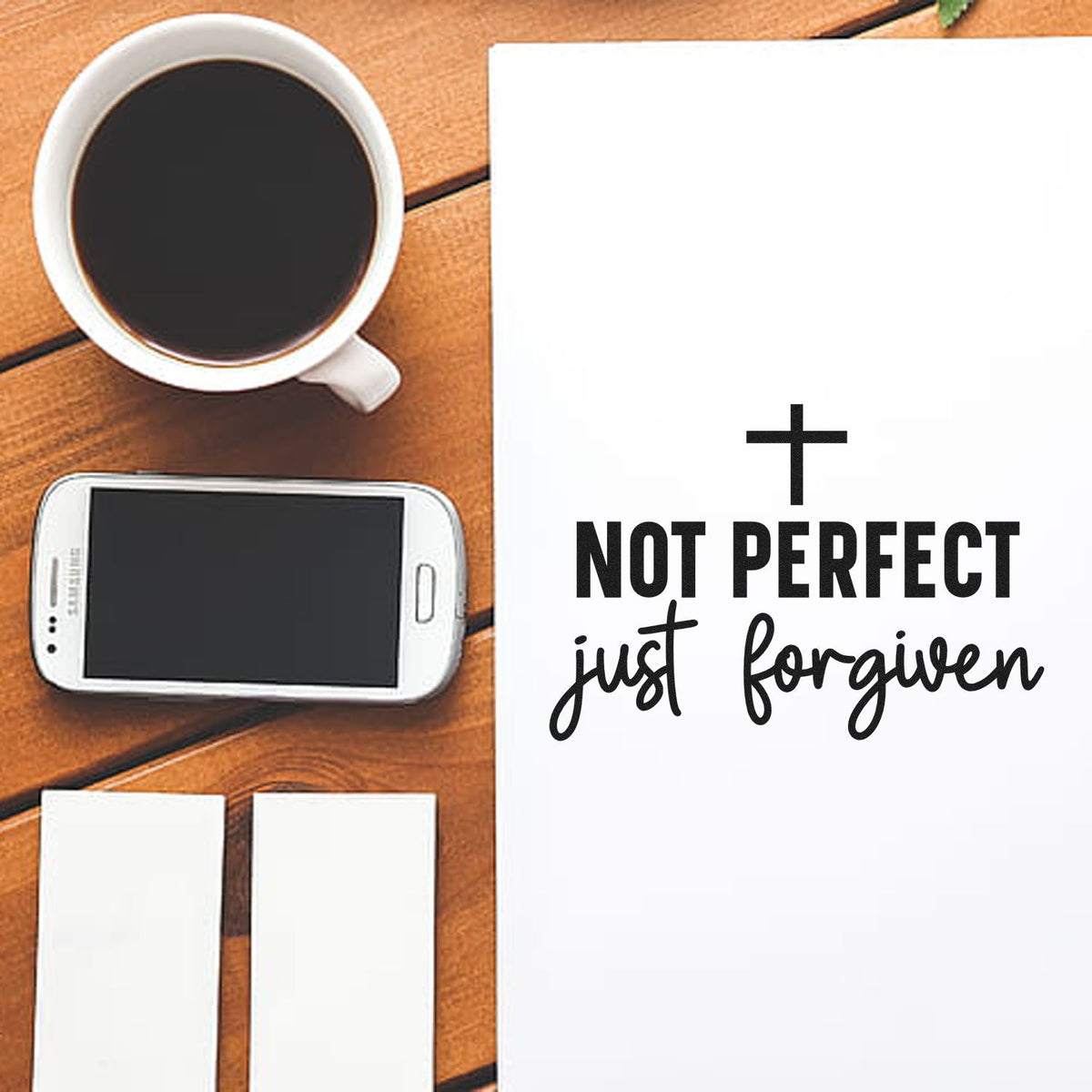 Not Perfect, Just Forgiven With Cross PSI Pre-Inked Stamp imprint stamped in black ink. A small cross tops "Not perfect, just forgiven" in bold and script lettering.