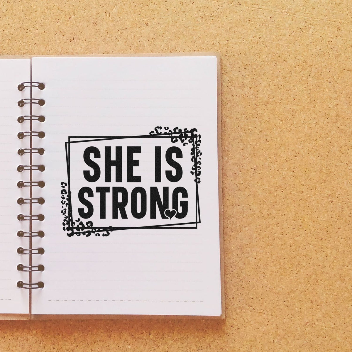 She Is Strong rubber stamp design on a notebook page, ideal for empowering journaling, scrapbooking, and handmade crafts.
