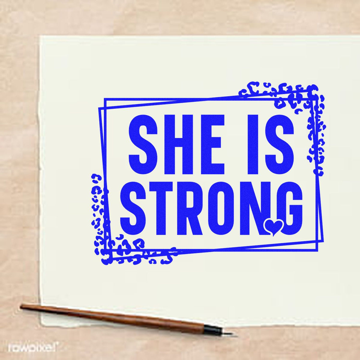 Blue rubber stamp design with She Is Strong in bold letters, framed by a decorative border, for inspirational paper crafting and journaling.