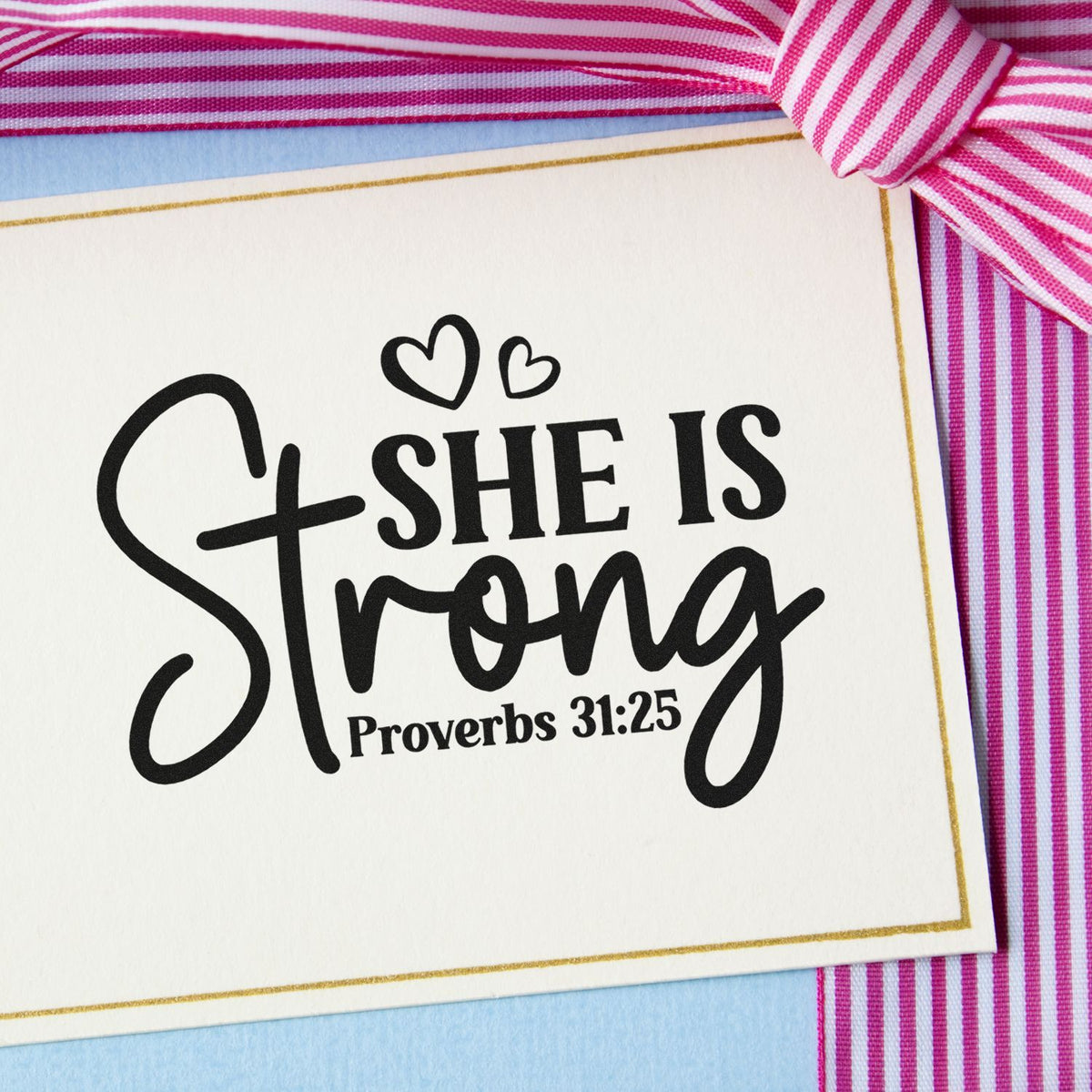 She Is Strong Proverbs 31:25 rubber stamp on a greeting card with hearts and pink ribbon.