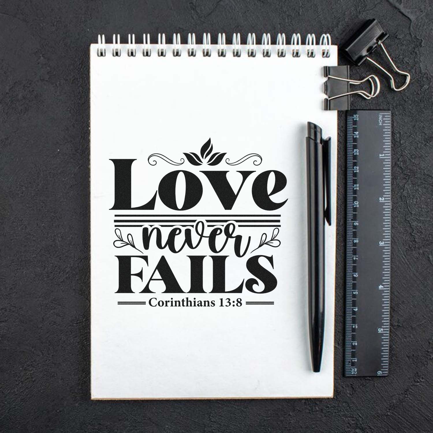 Christian rubber stamp design reading Love Never Fails with Corinthians 13:8 for crafts, notebooks, and gifts