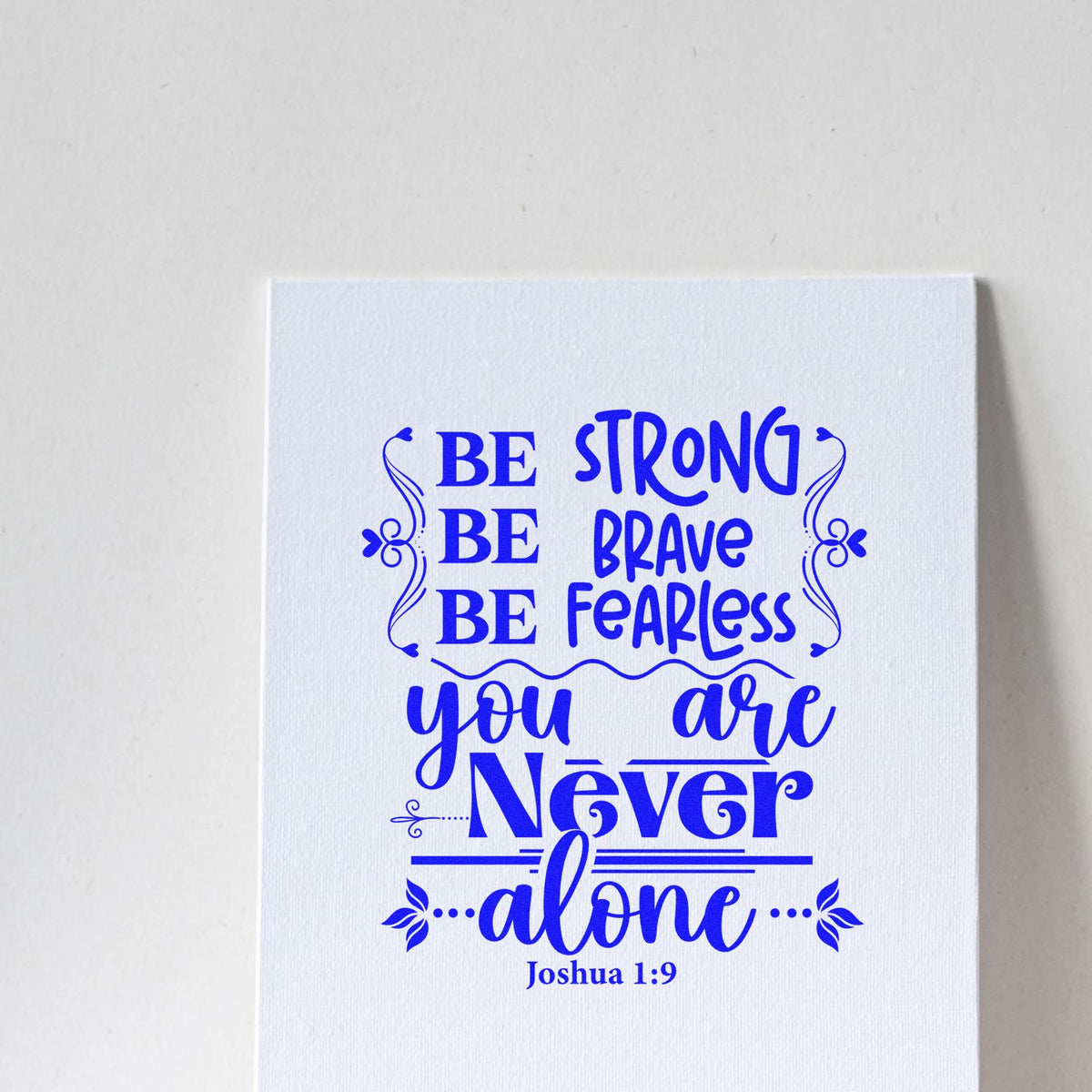 Blue Joshua 1:9 Bible verse rubber stamp reading Be strong, be brave, be fearless, you are never alone on white paper.
