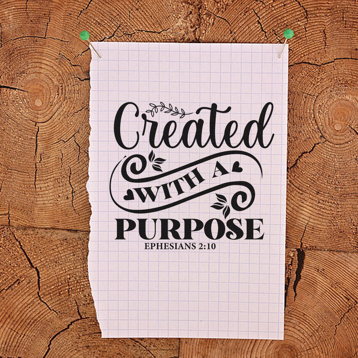 Christian rubber stamp design reading Created with a Purpose with Ephesians 2:10 on pinned paper over wood background.