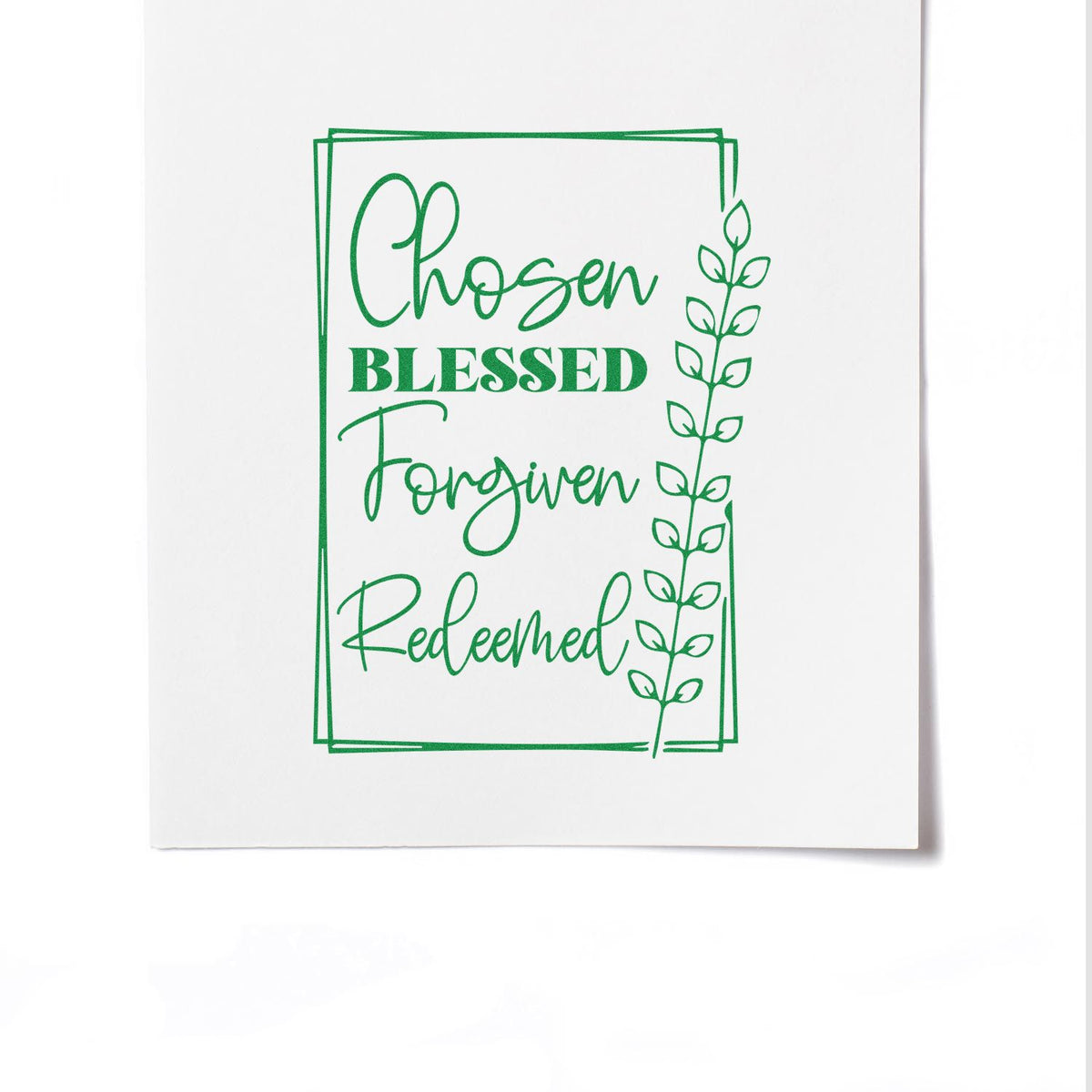 Green Christian rubber stamp impression reading Chosen Blessed Forgiven Redeemed with leafy border on white paper.