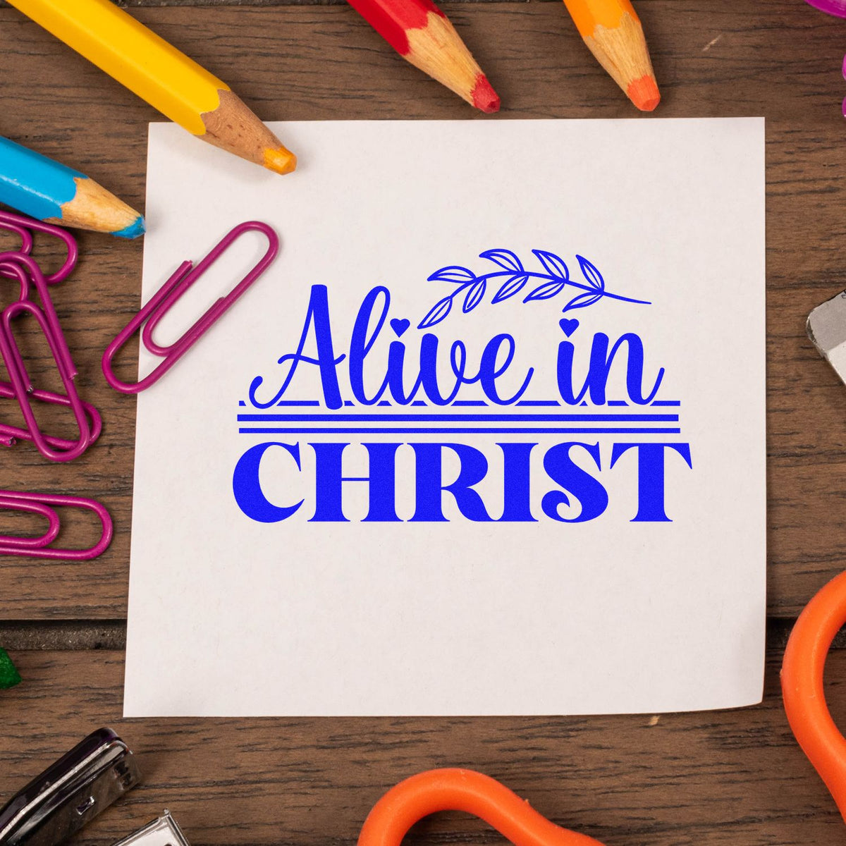Alive in Christ rubber stamp design on paper with colorful pencils and paper clips for Christian crafts.