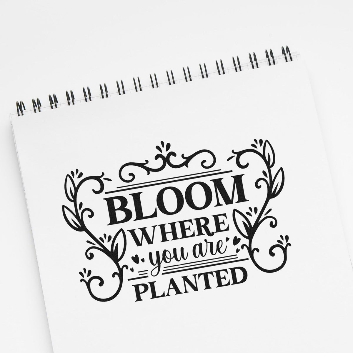 Decorative rubber stamp design reading Bloom where you are planted with floral accents for crafting and journaling.