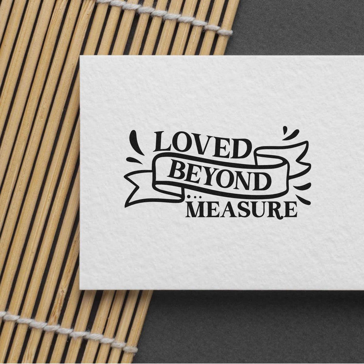 Custom rubber stamp impression reading Loved Beyond Measure on white paper, perfect for handmade cards and craft packaging.