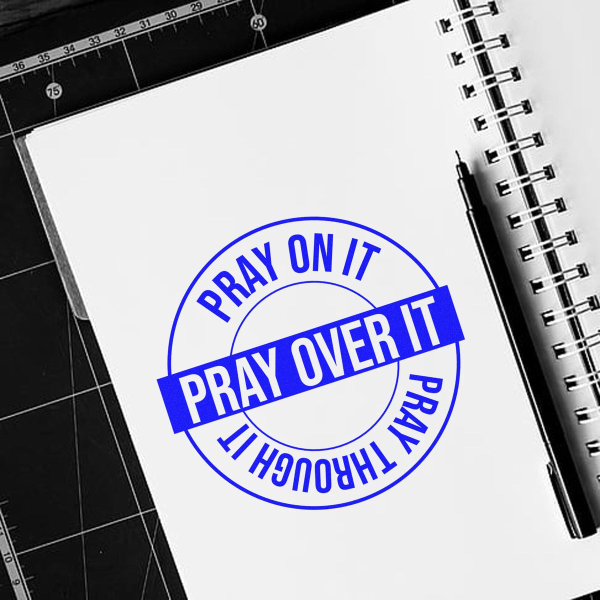 Blue Pray on It, Pray Through It rubber stamp on notebook paper for faith-based journaling and craft projects.