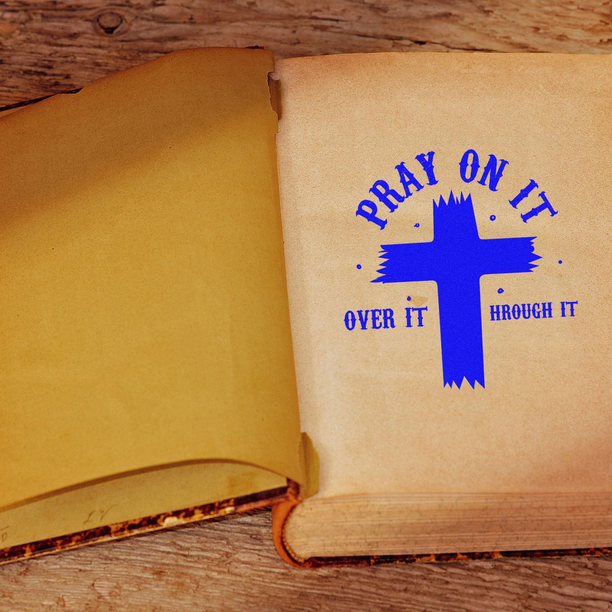 Christian rubber stamp design on open book reading Pray on it, over it, through it with blue cross.