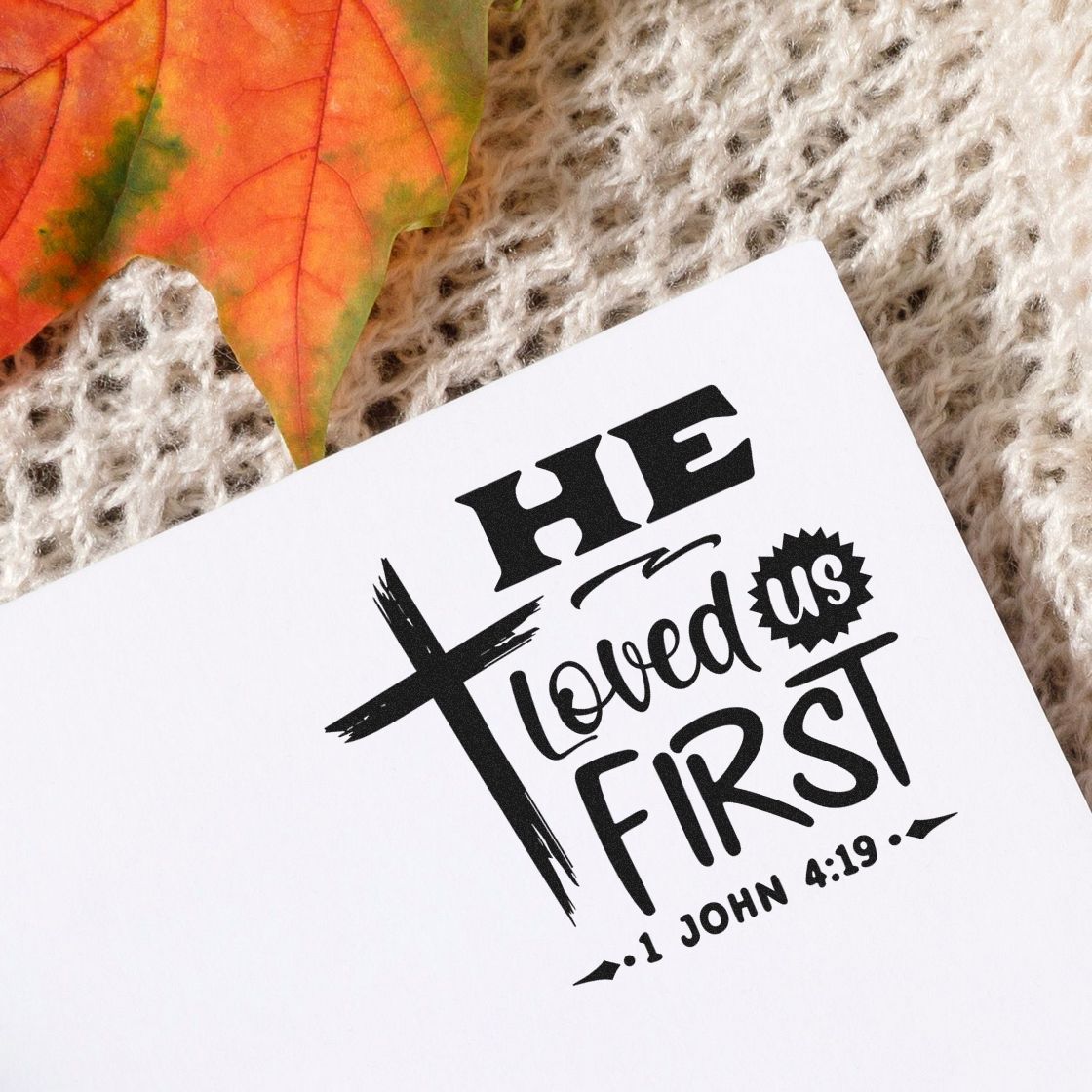 Christian rubber stamp with cross and quote He loved us first from 1 John 4:19 for faith crafts and card making.